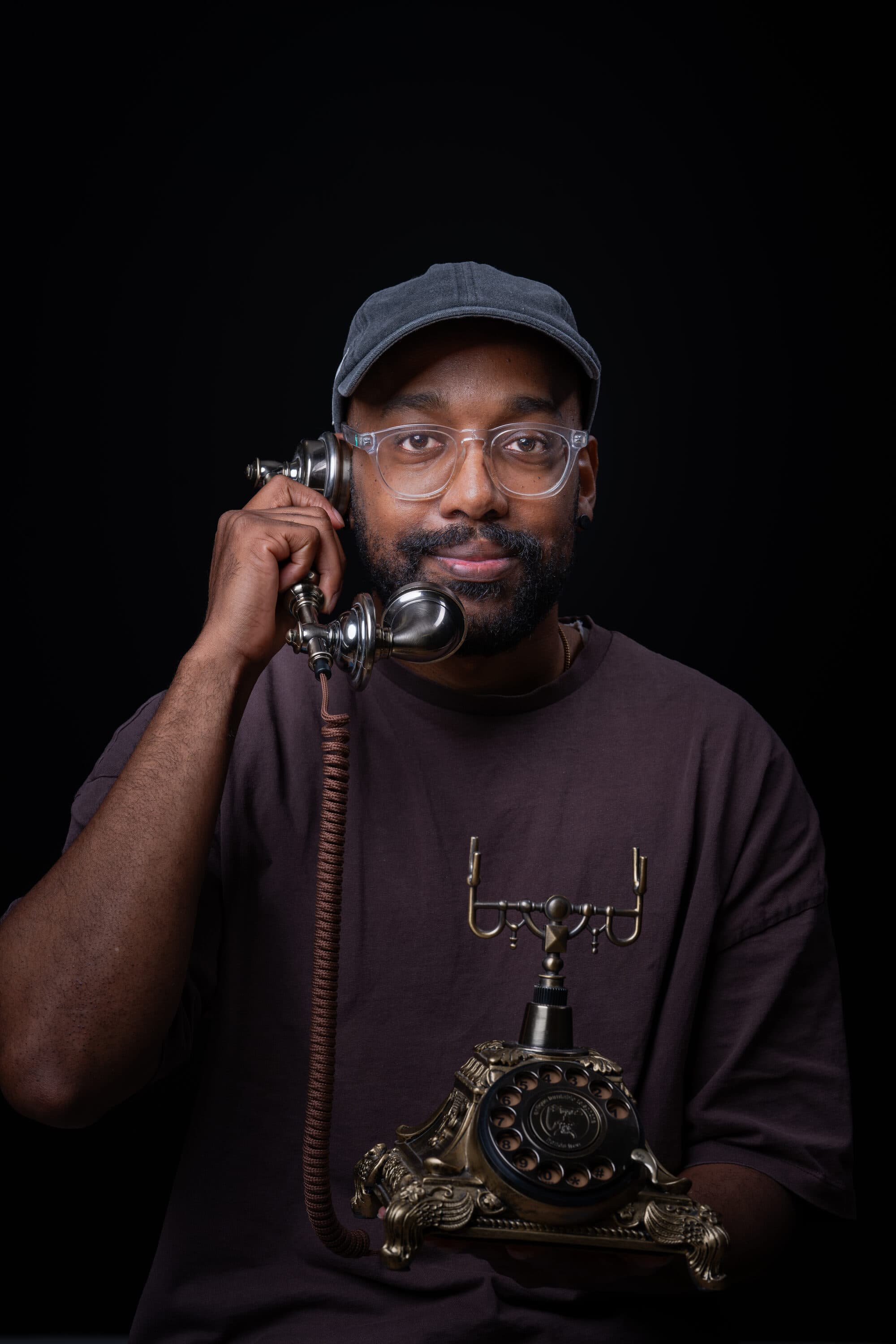 Een barry met een bril en een klassieke telefoon aan het oor