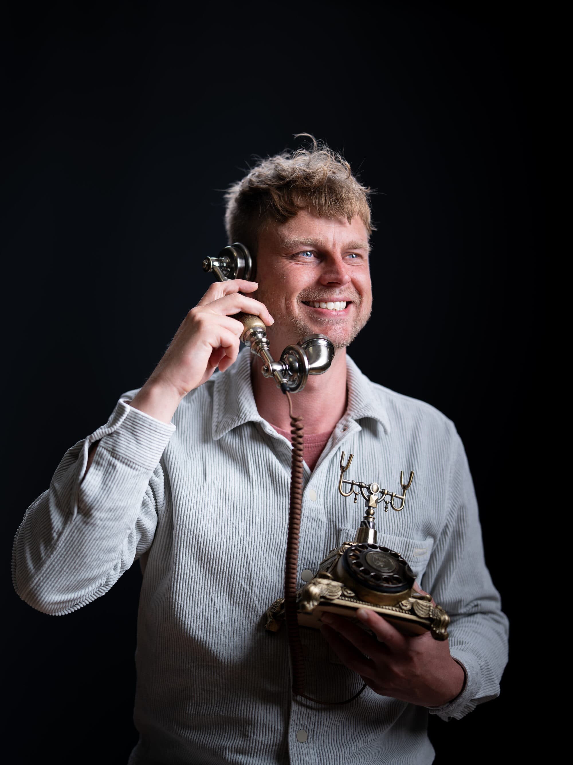 Een lachende barry met een klassieke telefoon in de hand